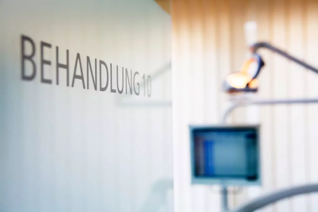 Die Beschriftung Behandlung 10 auf einer Tür in der Zahnarztpraxis in Köln.