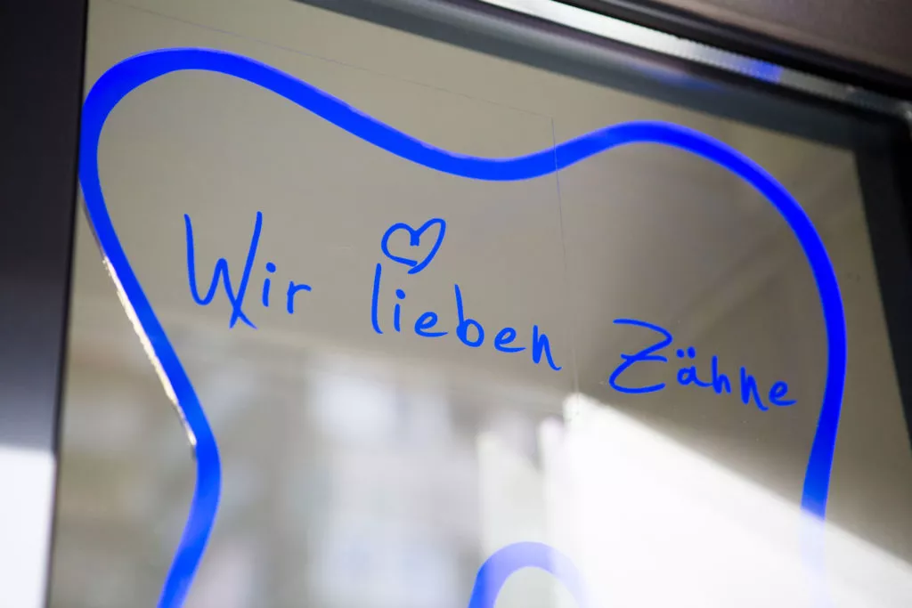 Bild mit dem Slogan der Praxis "Wir lieben Zähne"